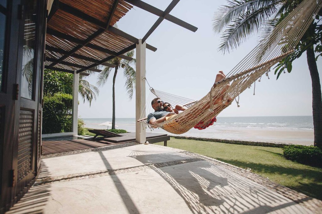 couple-relaxing-in-a-hammock-by-the-beach-9FE8MAG.jpg